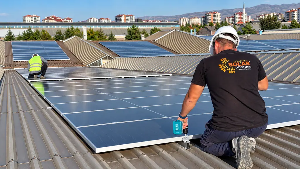 Endüstriyel çatıda güneş paneli montajı yapan Solar Doctors teknisyeni
